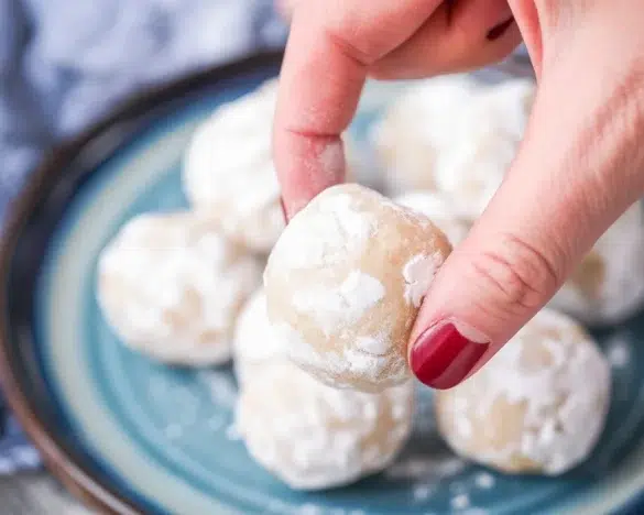 A plate of buttery snowball cookies dusted with powdered sugar, ideal for holiday treats.
