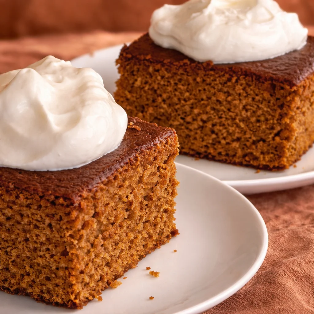 Delicious Grandma's Gingerbread Cake topped with cream, ideal for festive meals.