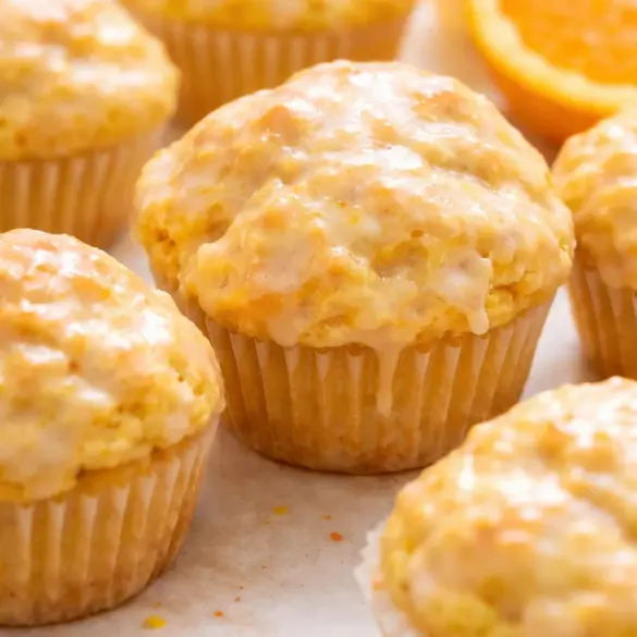 Freshly baked orange vanilla buttermilk muffins with a golden top and citrus glaze.