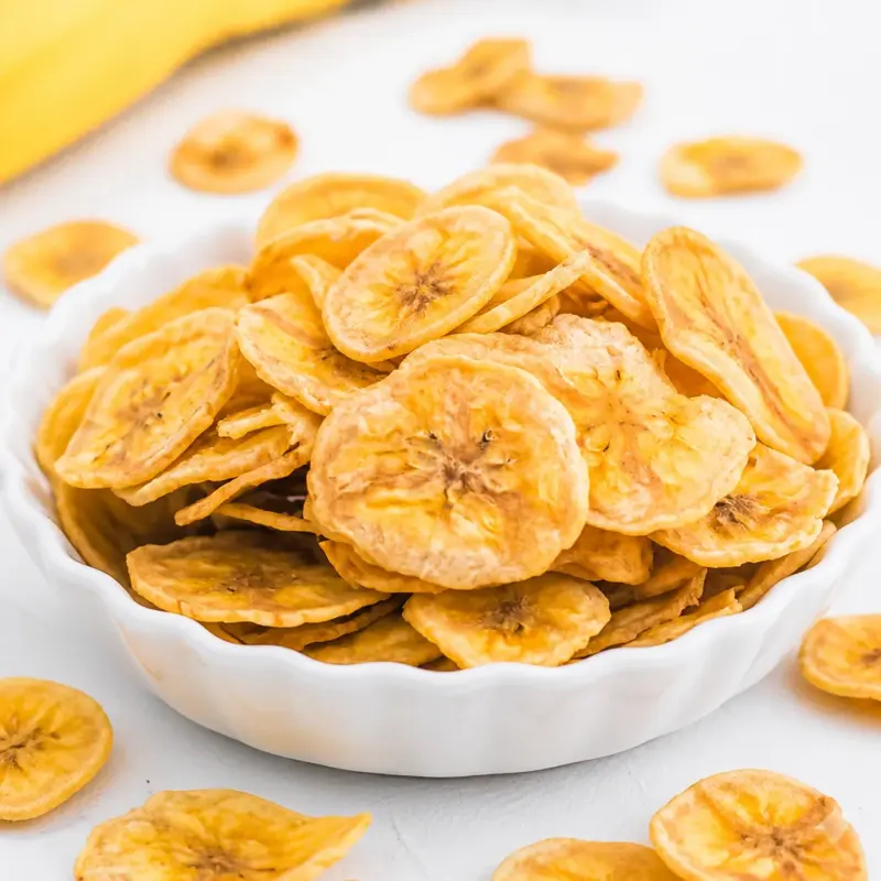 Crispy air fryer banana chips on a plate, a healthy and sweet snack option